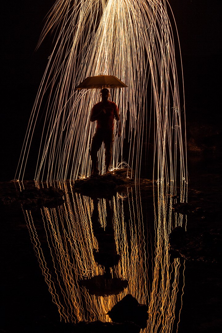photo de nuit d'un homme avec reflet dans l'eau, drone, de la paille de fer
