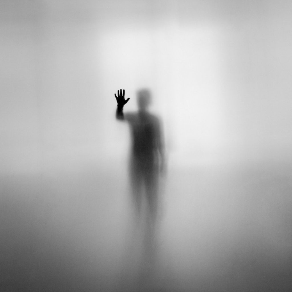 Ombre d'un homme derrière une vitre, photo en noir et blanc