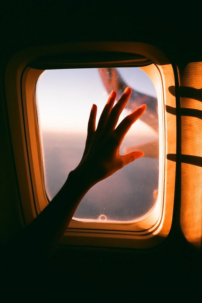 main devant le hublot dans un avion