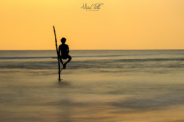 Pêcheur au coucher du soleil en Asie