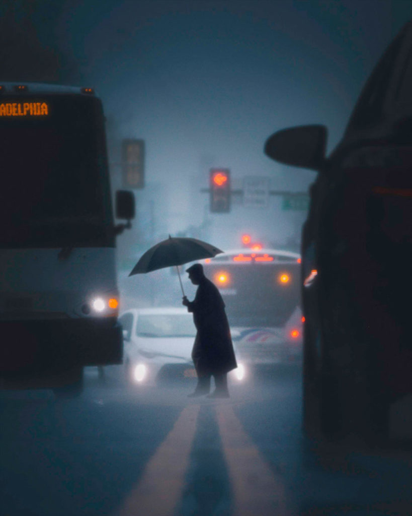 homme tenant un parapluie traverse la rue par Chris Hytha